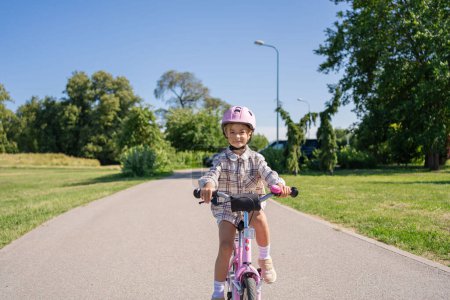 Foto de Alegre niño monta en una bicicleta en el parque de la ciudad al aire libre. - Imagen libre de derechos
