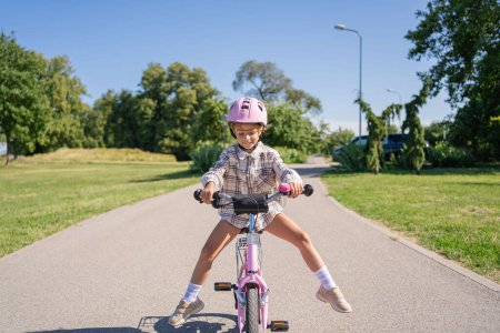Photo for Cheerful child rides on a Bicycle in city park outdoor. - Royalty Free Image