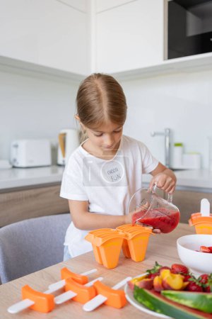 Téléchargez les photos : Enfant fille cuisson baies popsicles à la maison - en image libre de droit