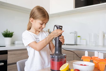 Photo for Portrait of cute child girl making ice cream. Kid have fun making with homemade fruit puree ice cream. Home made ice lollies. High quality photo - Royalty Free Image