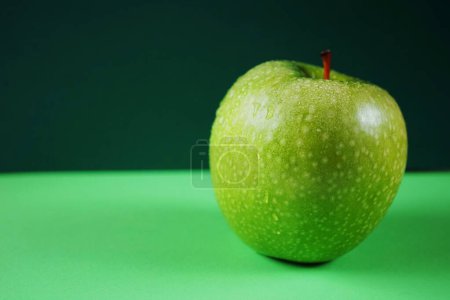 Téléchargez les photos : Pomme verte mûre sur fond vert - en image libre de droit