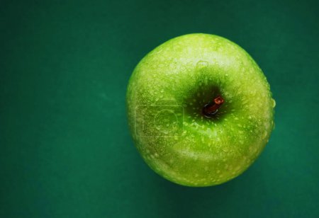 Téléchargez les photos : Pomme verte mûre sur fond vert - en image libre de droit