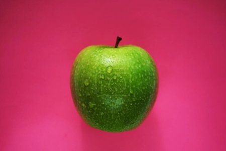 Téléchargez les photos : Pomme verte mûre sur fond rose - en image libre de droit