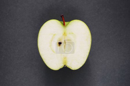Téléchargez les photos : Une demi pomme verte mûre sur fond gris - en image libre de droit