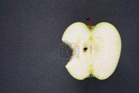 Téléchargez les photos : Une demi pomme verte mûre sur fond gris - en image libre de droit