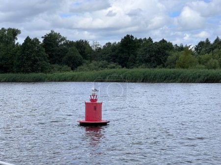 Téléchargez les photos : Bouée rouge flottante rouge de navigation et oiseau sur les eaux bleues de la rivière Nemunas. Bouée dans la rivière. Équipement de navigation. Surface de l'eau tranquille. Photo de haute qualité - en image libre de droit