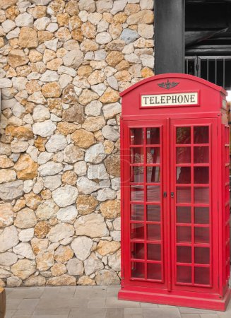 Photo for This is one of the spots or points for taking pictures, a stone-textured wall and a red telephone miniature wooden cupboard. no people - Royalty Free Image