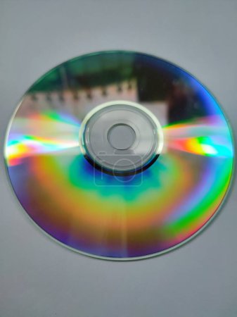 Téléchargez les photos : Les CD qui sont exposés à la lumière et émettent des couleurs colorées sont isolés sur un fond blanc - en image libre de droit