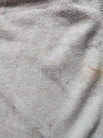Textur, Muster, Hintergrund des schmutzigen weißen Handtuchs, das dem Sonnenlicht ausgesetzt ist