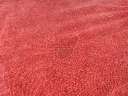 Textur, Muster, Hintergrund des roten Handtuchs, das dem Sonnenlicht ausgesetzt ist