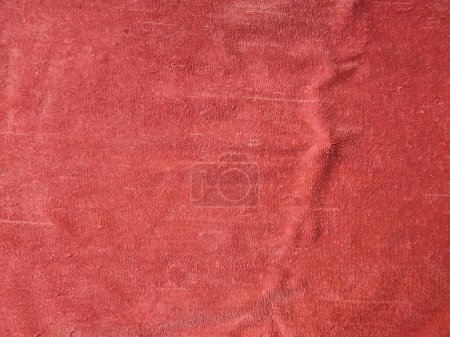 Textur, Muster, Hintergrund des roten Handtuchs, das dem Sonnenlicht ausgesetzt ist