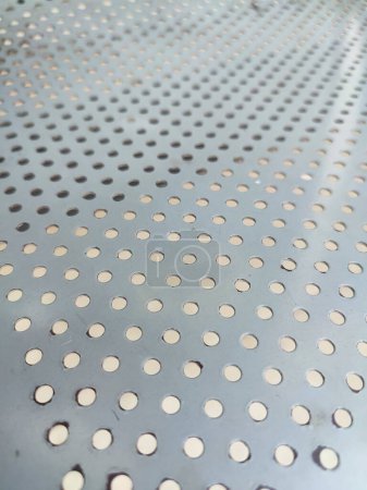 Perforated white metal panel background. White metal plate with dots. Aluminum punching metal