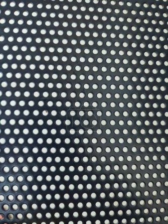 Perforated black metal panel background. White metal plate with dots. Aluminum punching metal