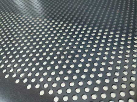 Perforated black metal panel background. White metal plate with dots. Aluminum punching metal