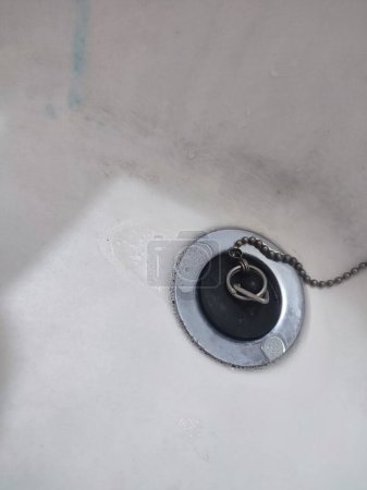 Desagüe del lavabo de metal aislado en blanco. El agujero del fregadero en la cocina