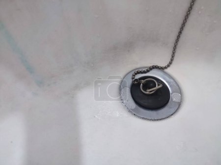 Desagüe del lavabo de metal aislado en blanco. El agujero del fregadero en la cocina