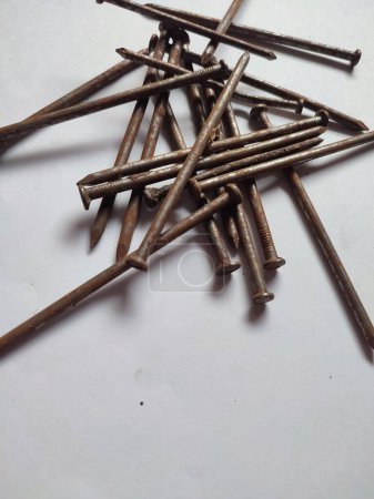 some scattered rusty nails on a white background