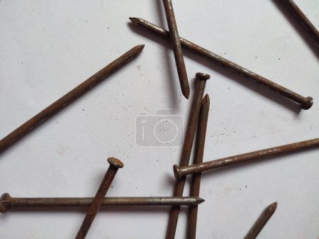 Foto de Algunas uñas oxidadas dispersas sobre un fondo blanco - Imagen libre de derechos