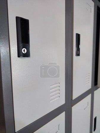 Photo for Keep white and gray box lockers or gym lockers indoors with one center door open - Royalty Free Image