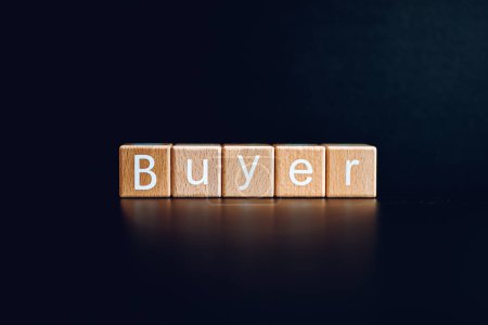 Wooden blocks form the text "Buyer" against a black background.