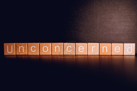 Wooden blocks form the text "Unconcerned" against a black background.