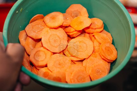 main prenant quelques morceaux de carotte coupée dans la cuisine