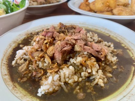 Téléchargez les photos : Close-up photo of Rawon (black beef soup). Originating from Ponorogo, East Java, rawon uses black kluwek nuts as its main seasoning, giving the broth its dark color and spicy flavor. - en image libre de droit