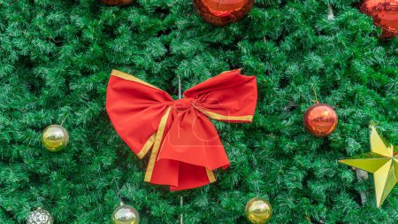 Foto de Imagen de un lazo rojo gigante El bulto en el árbol de Navidad se asemeja a un gran regalo envuelto. que está listo para dar felicidad a todos durante el festival de Nochevieja - Imagen libre de derechos
