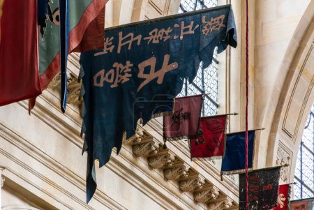Foto de Banderas históricas de ejércitos derrotados en exhibición dentro de la Iglesia Les Invalides, un símbolo de la historia militar en París, Francia. - Imagen libre de derechos