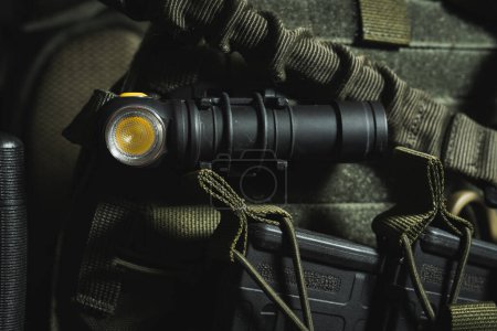 Tactical flashlight on military equipment, close-up photo. High quality photo