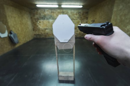 Téléchargez les photos : Tir au pistolet tactique sur une cible en papier dans un champ de tir. Photo de haute qualité - en image libre de droit
