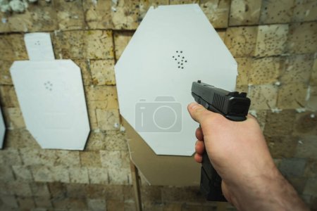 Téléchargez les photos : Tir au pistolet tactique sur une cible en papier dans un champ de tir. Vue 3d. - en image libre de droit