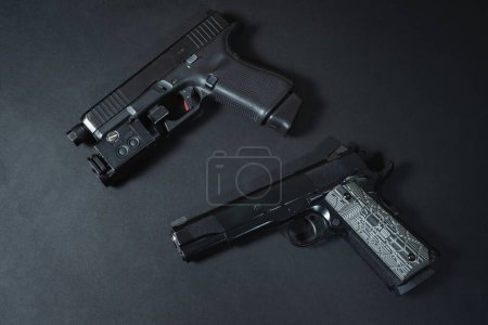 Foto de Dos pistolas de calibre 9mm y 45acp, foto de primer plano sobre fondo negro. Foto de alta calidad - Imagen libre de derechos