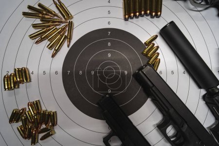 Photo for Firearms, paper target for shooting, pistols, silencer and cartridges. High quality photo - Royalty Free Image