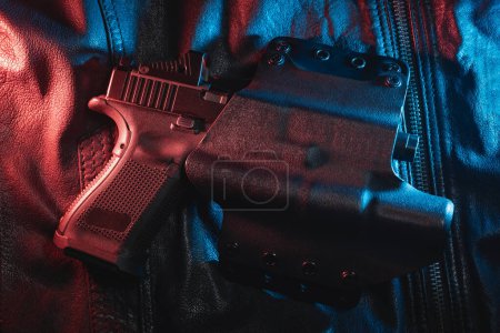 A pistol with a flashlight and a red dot sight in a holster, close-up photo. High quality photo