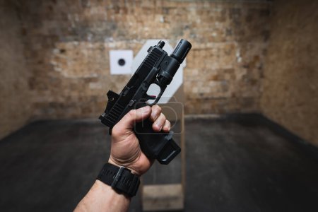 Téléchargez les photos : Tir tactique à partir d'un pistolet avec un point rouge sur des cibles dans un champ de tir. - en image libre de droit
