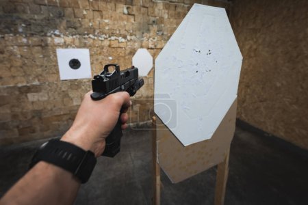 Téléchargez les photos : Tir tactique à partir d'un pistolet avec un point rouge sur des cibles dans un champ de tir. Photo de haute qualité - en image libre de droit