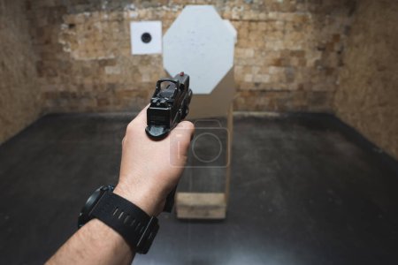 Téléchargez les photos : Tir tactique à partir d'un pistolet g19 avec un point rouge sur les cibles dans un champ de tir. - en image libre de droit