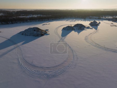 Nature of Estonia, car road on the frozen lake with islands, photo from a drone. 