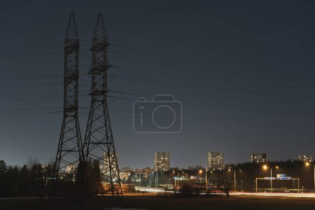 Photo de nuit. Lignes de transport d'électricité dans le contexte de la ville de nuit et de l'autoroute, Tallinn. Photo de haute qualité