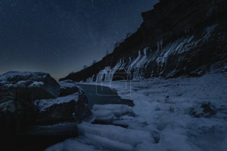 Night winter scene pf Estonian nature, view of the Paldiski frozen sea cliff and the starry sky. 