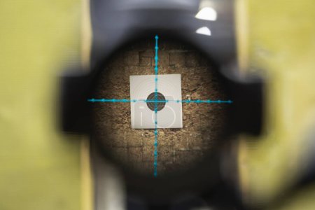 View through the optical sight of a sniper rifle at a target in a shooting range. Close up photo. 