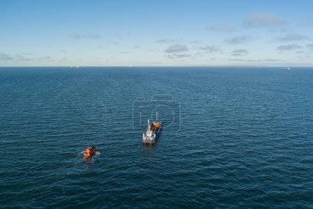 The pilot's ship approaches the dry cargo ship. High quality photo