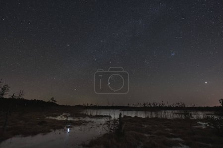 Landschaft-Astrofotografie, See im Seli-Sumpf im Winter in einer sternenklaren Nacht. 