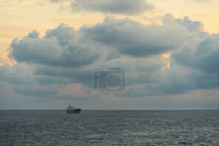 Dry cargo ship in the Baltic sea at dawn, sky with clouds. 