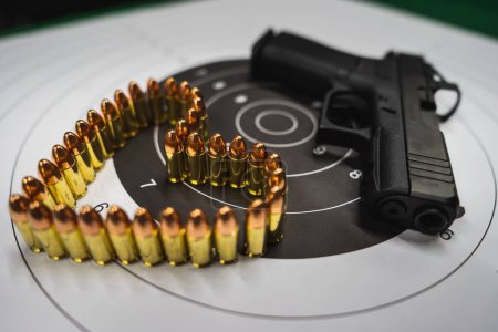 A shooting target, a modern 9mm pistol and a heart made of cartridges. 