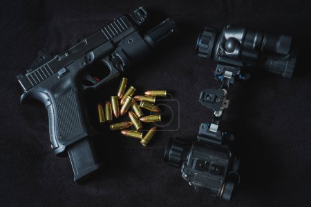 Military night vision device and tactical pistol with flashlight and red dot and 9mm cartridges. 