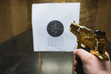 Shooting at a shooting range with a powerful golden Desert Eagle pistol. 