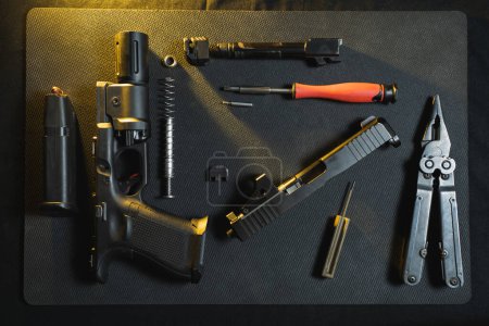 Gunsmithing, cleaning and repairing weapons. Disassembled pistol g19 in a workshop. 
