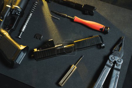 Gunsmithing, cleaning and repairing weapons. Disassembled pistol in a workshop. 